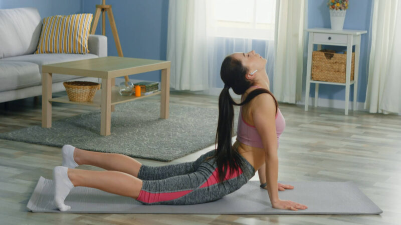 A girl practicing yoga, performing the Cobra pose